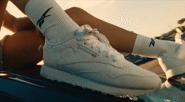 a pair of white shoes sitting on top of a car
