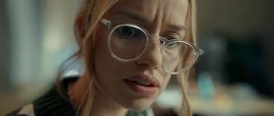a woman wearing glasses looking at the camera