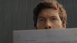 a man holding a piece of paper in front of his face