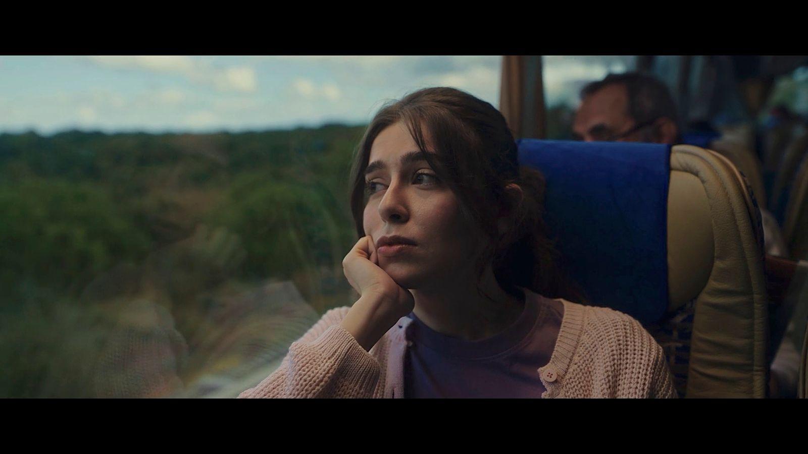 a woman sitting on a bus looking out the window