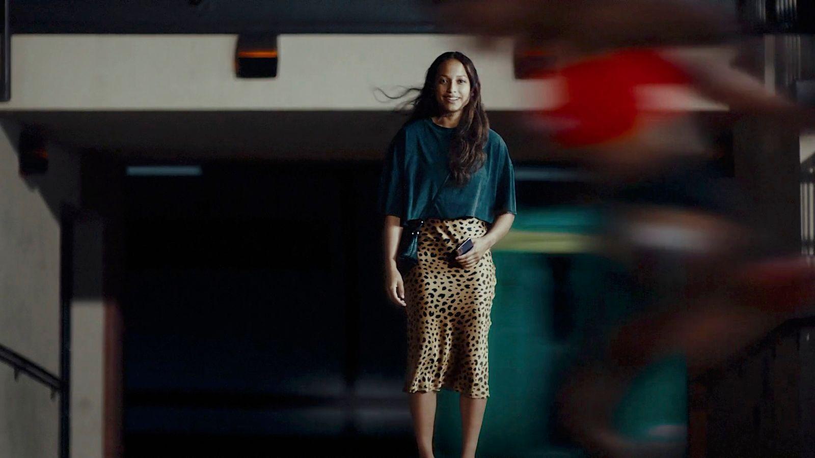a woman standing in a hallway with a leopard print skirt