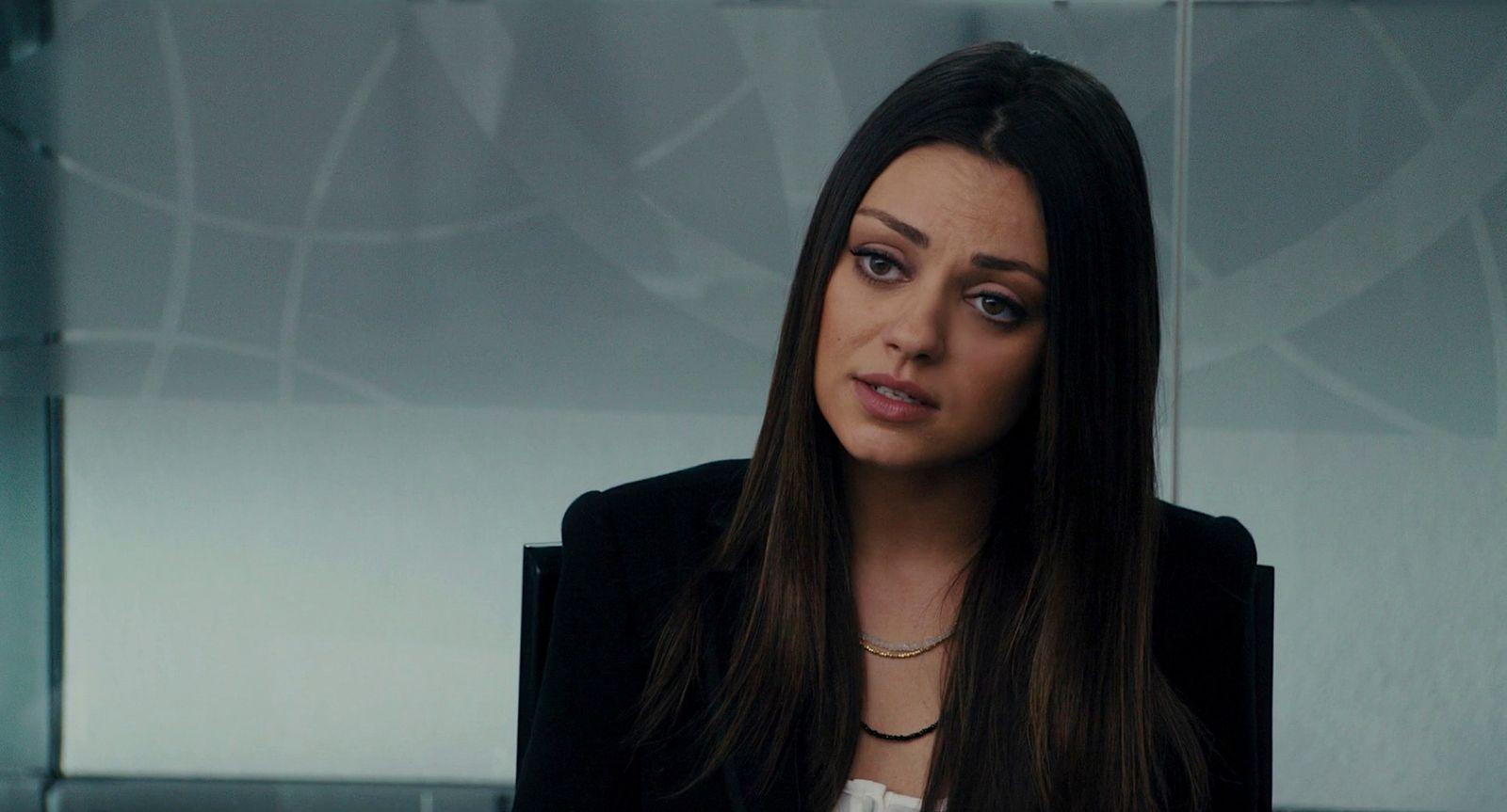 a woman in a black jacket looking at the camera