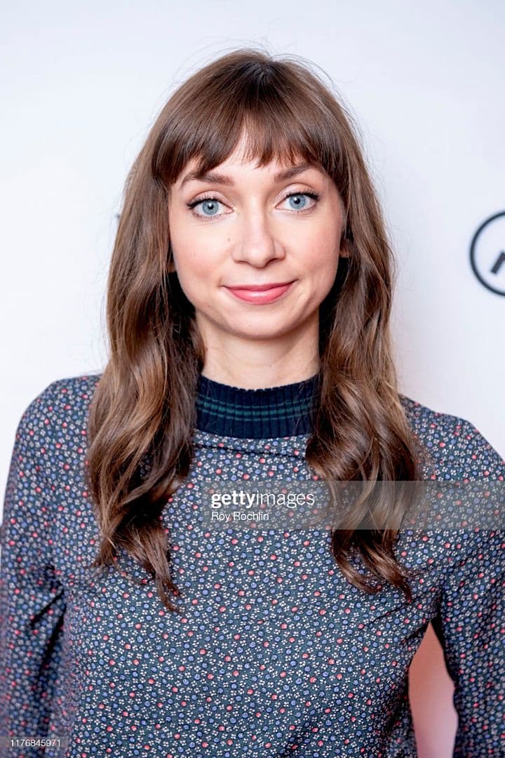 a woman in a blue dress poses for a photo