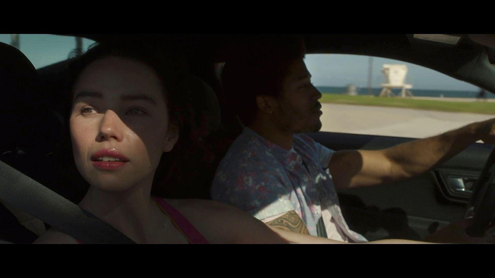 a man driving a car next to a woman