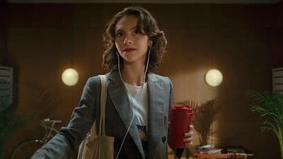 a woman in a suit holding a red cup