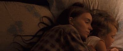 a woman and a child laying on a bed