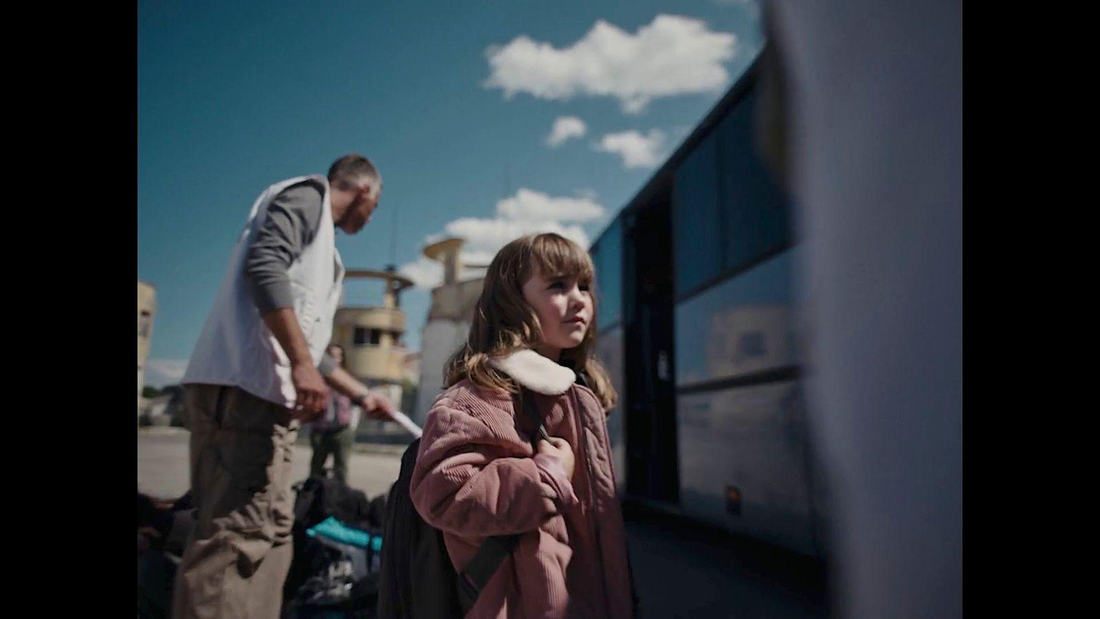 a man and a woman standing next to a train