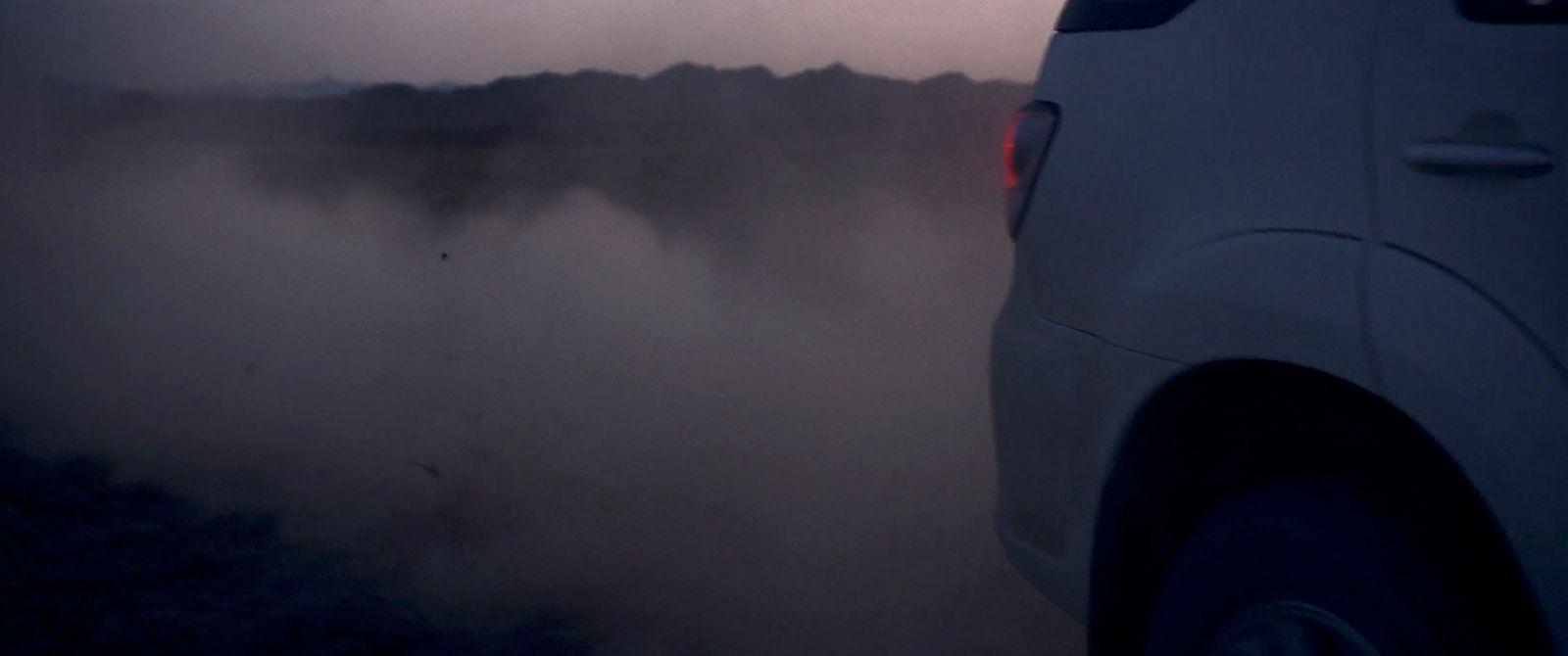 a car driving on a foggy road at night