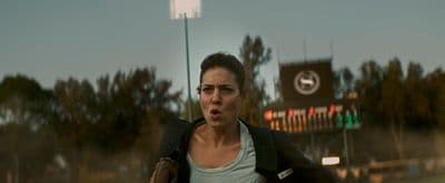 a woman making a surprised face in front of a stadium