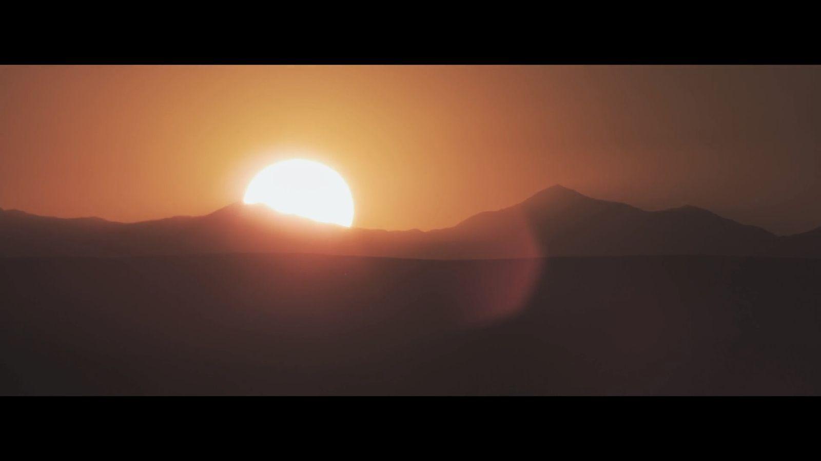 the sun is setting over a mountain range