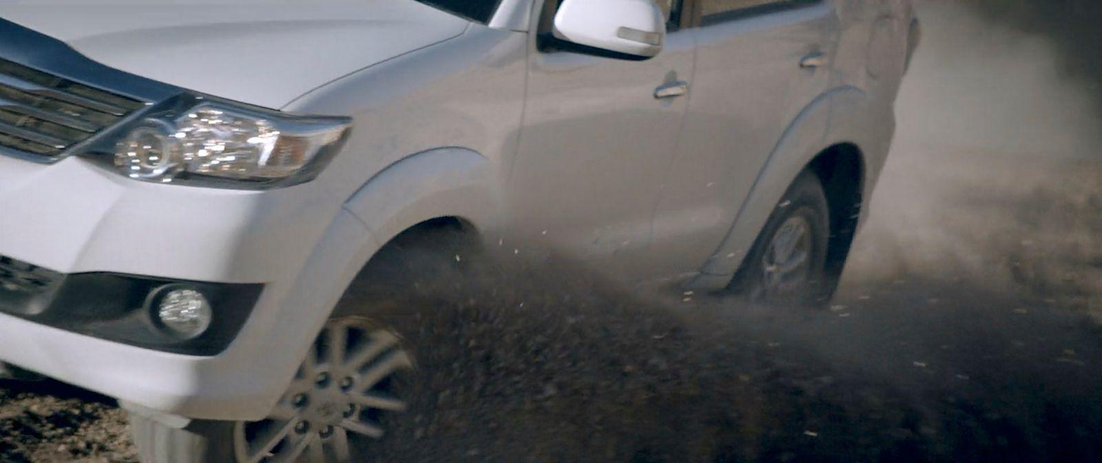a white truck driving down a dirt road