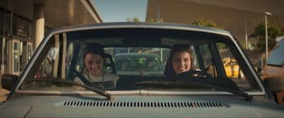 two women sitting in a car talking to each other