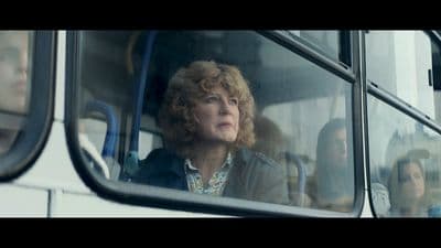 a woman looking out the window of a bus
