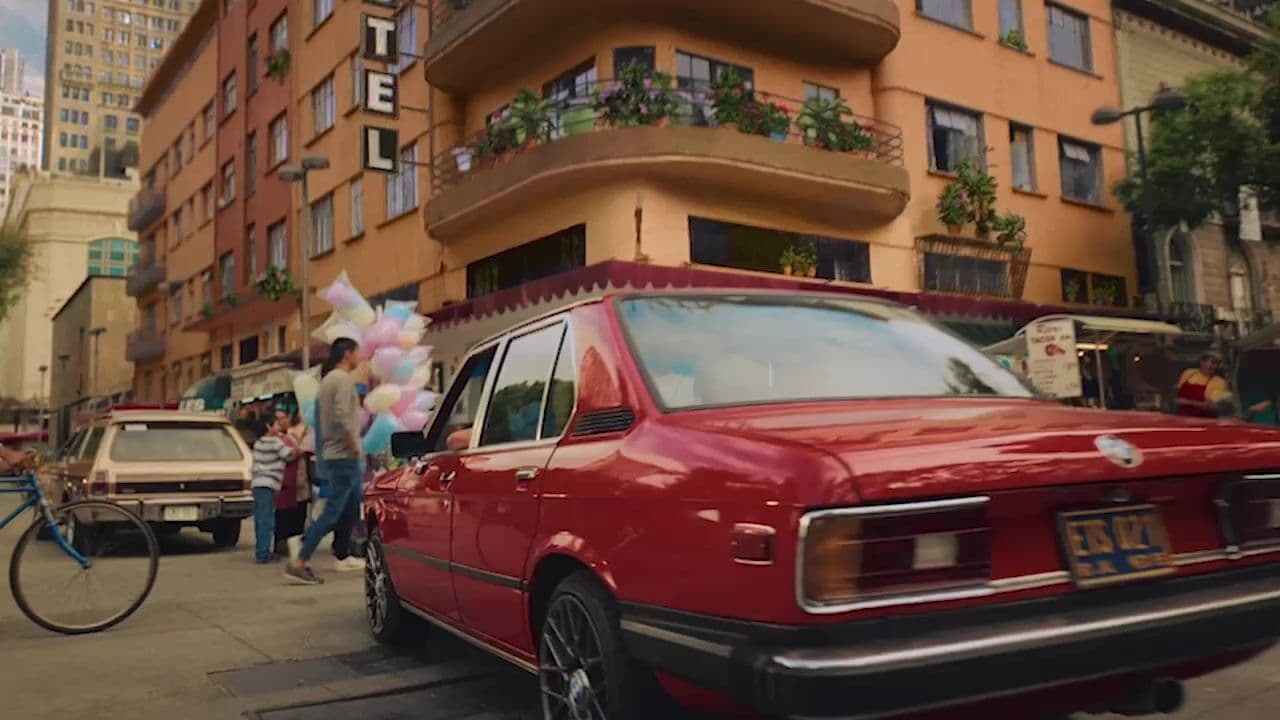 a red car parked in front of a tall building