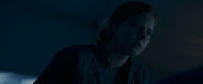a woman standing in a dark room looking at something