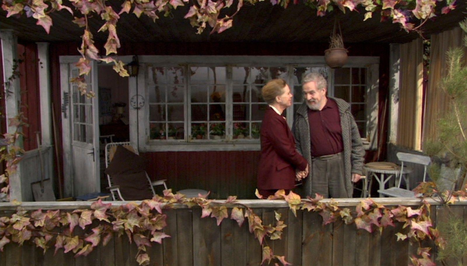 a man and a woman standing in front of a house
