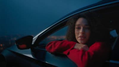 a woman sitting in a car looking out the window