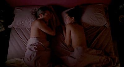 a couple of people laying in a bed next to each other