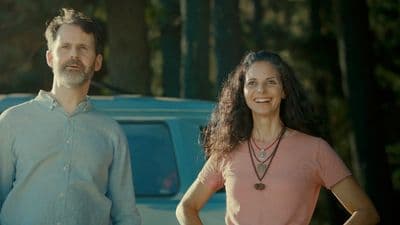 a man and a woman standing in front of a van