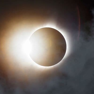 a solar eclipse is seen through the clouds