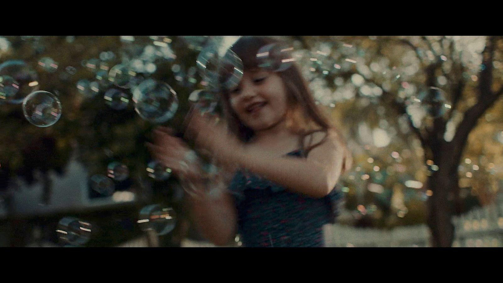 a young girl is playing with soap bubbles
