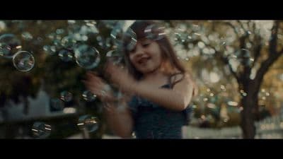 a young girl is playing with soap bubbles