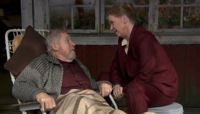 a woman sitting next to a man in a chair