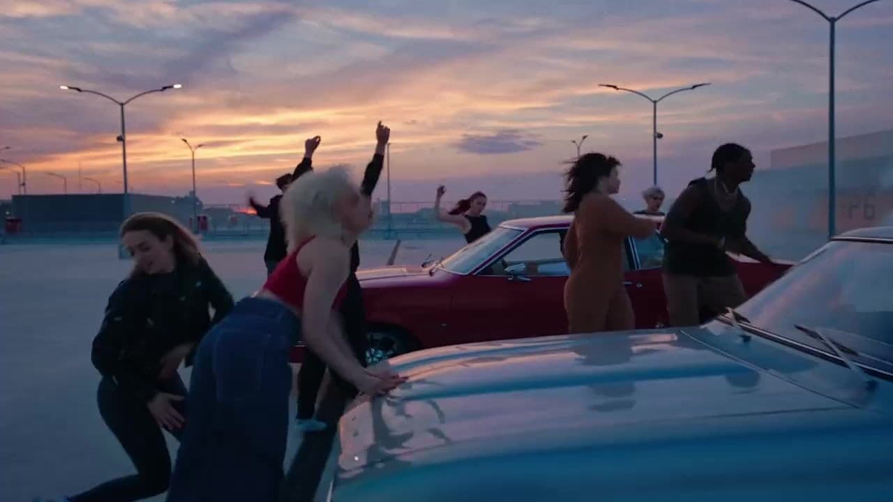 a group of people standing around a parked car