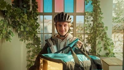 a man wearing a bicycle helmet holding a bag