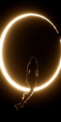 a woman standing in front of a circle of light