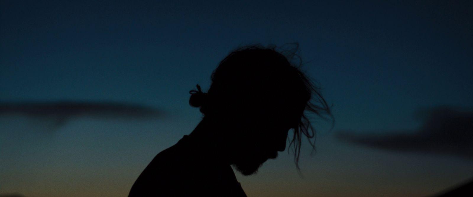 a silhouette of a man with a cigarette in his mouth