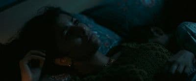 a woman laying on a bed talking on a cell phone