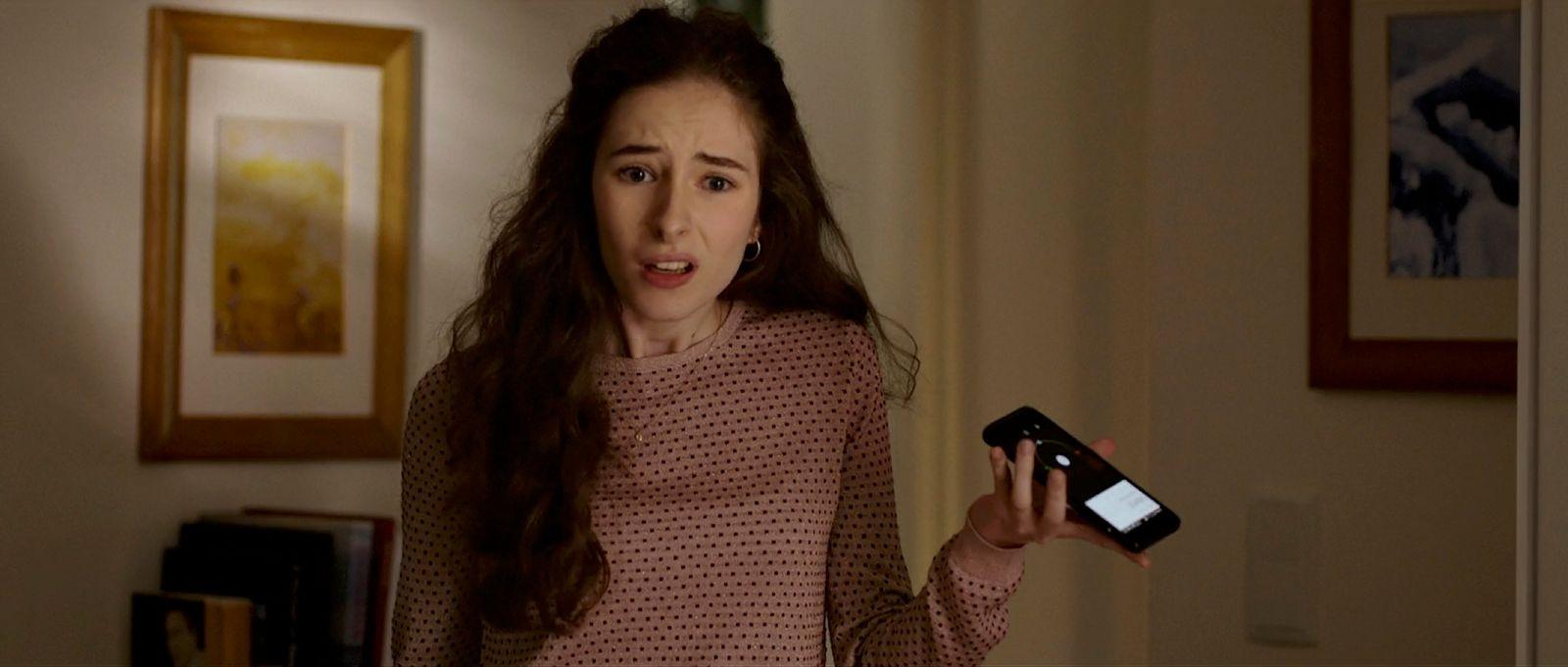 a woman holding a cell phone in her hand