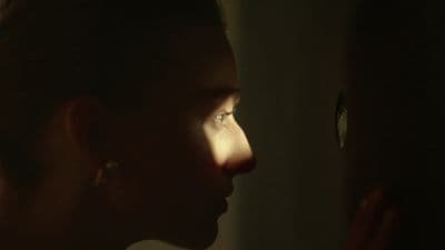 a woman in a dark room with a light shining on her face