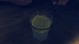 a glass of green liquid sitting on a table