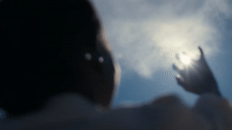a person reaching up into the sky with their hands