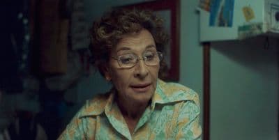 an older woman with glasses is staring at the camera