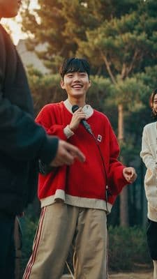 a young man standing next to a woman holding a microphone