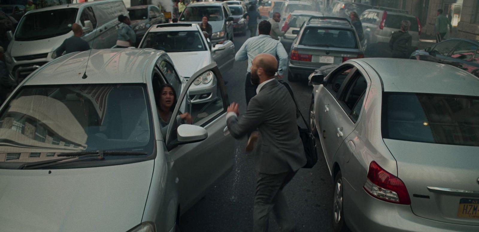 a man in a suit is getting out of a car
