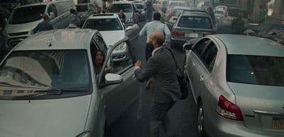 a man in a suit is getting out of a car