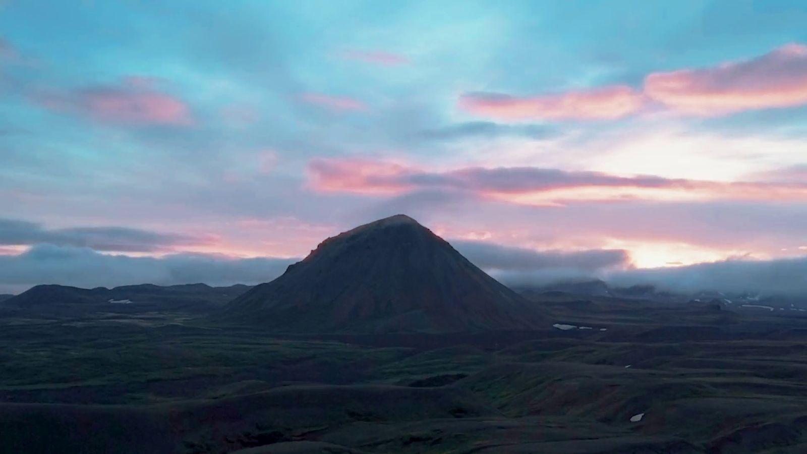a mountain with a sky filled with clouds