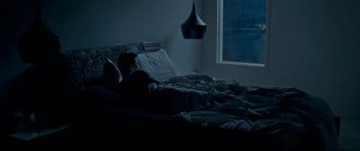 a person laying in a bed in a dark room