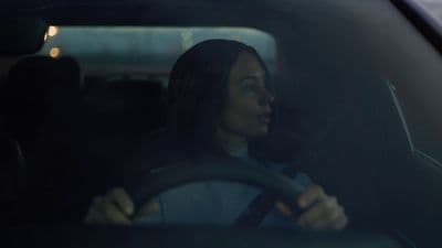 a woman driving a car in the dark
