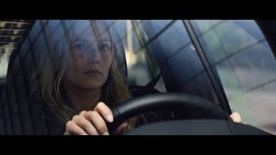 a woman driving a car with a steering wheel
