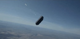 a small airplane flying through a blue sky