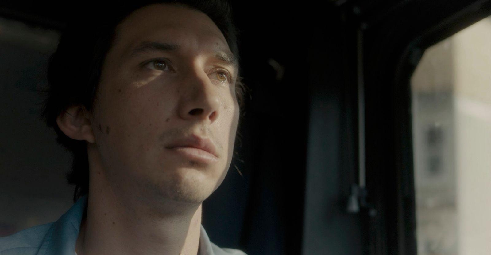 a man sitting in a car looking out the window