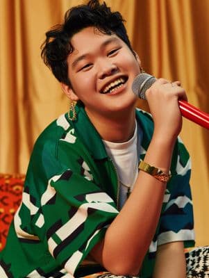 a young man holding a microphone and laughing