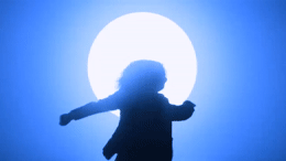 a silhouette of a person holding a bat in front of a full moon