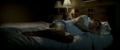 a man laying on a bed in a dark room