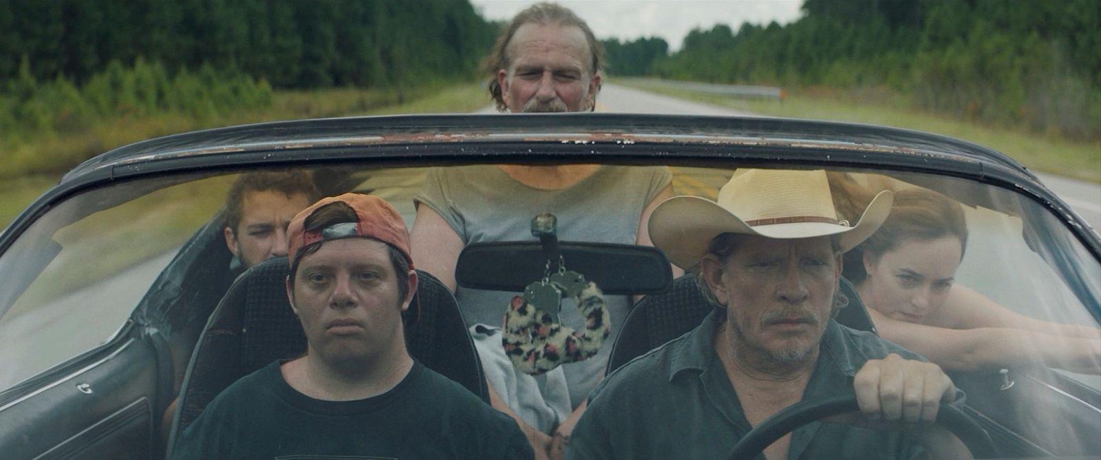 a group of people riding in a car on a road